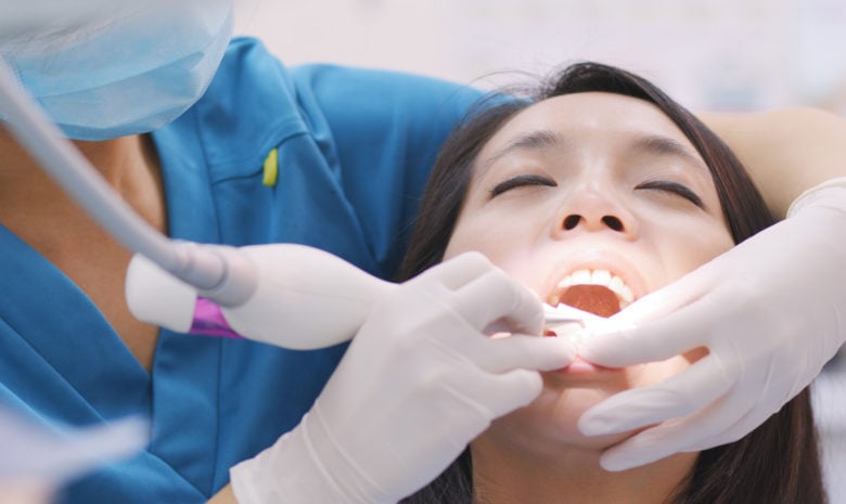 Woman with a doctor's hands in the mouth